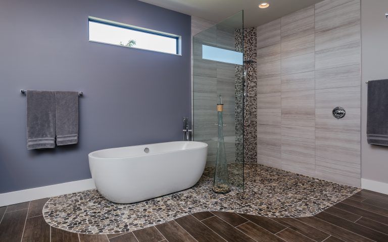 Contemporary master bath with soaking tub on pebble stone look tile floor surrounded by wood look tile floor