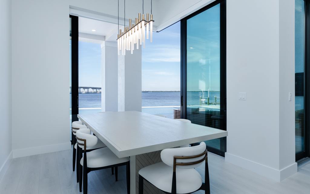 Modern family dining room opens to outdoor living at home built by Aubuchon Homes.