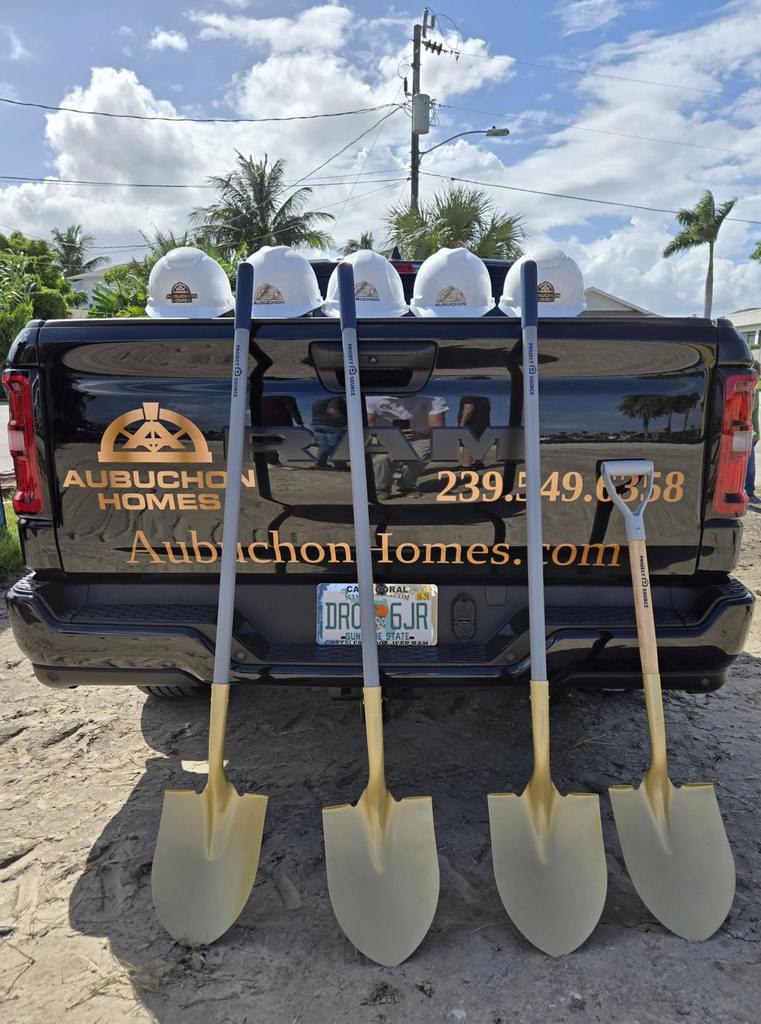 Golden shovels and hard hats on top of an Aubuchon Homes branded truck.