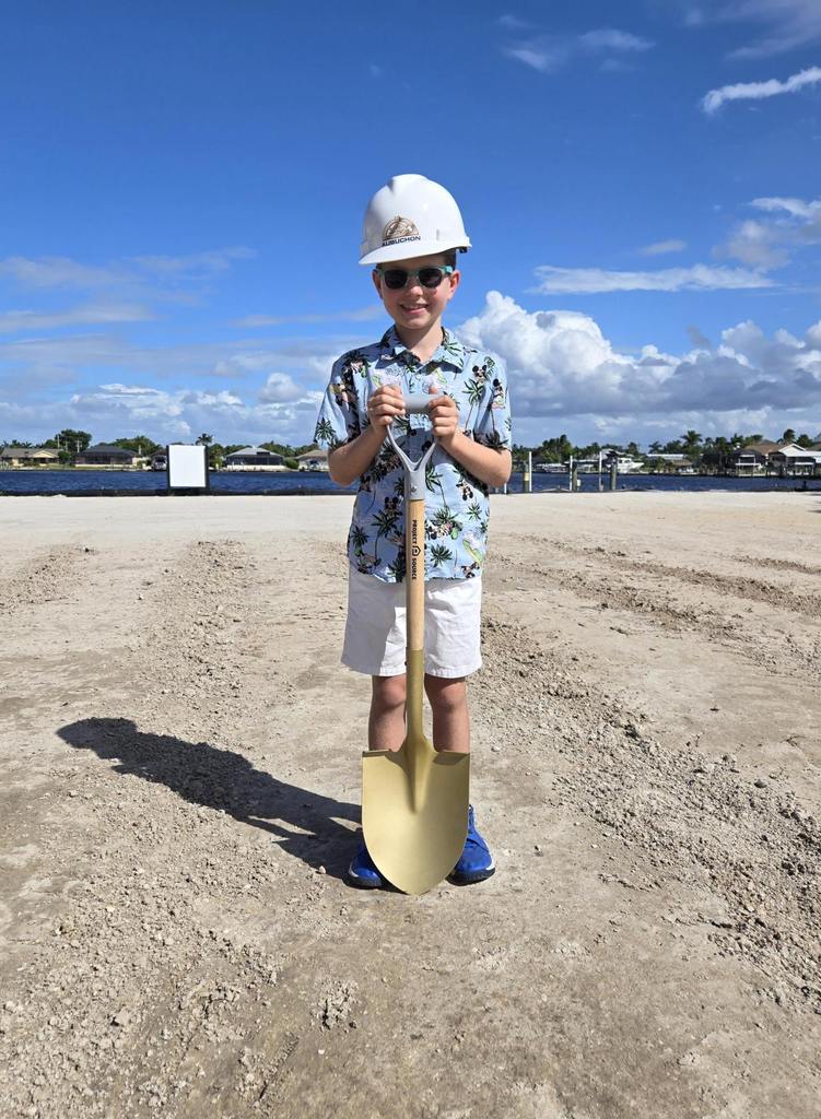 Child with shovel at groundbreaking for Aubuchon Homes.