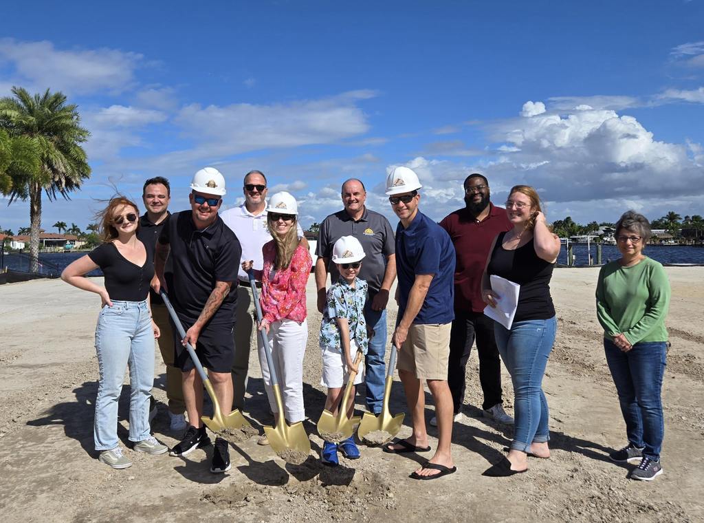 Family with shovels at groundbreaking ceremony with Aubuchon Homes team members.